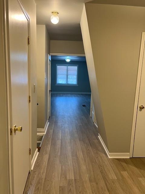 hall with wood finished floors and baseboards