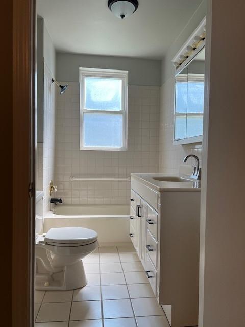 full bath with shower / washtub combination, vanity, toilet, and tile patterned floors