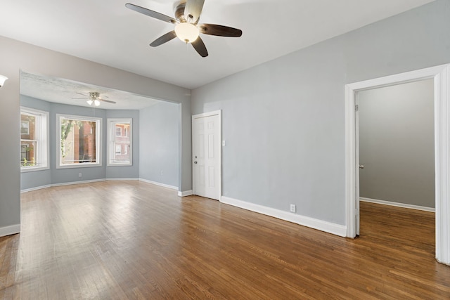 empty room with dark wood-type flooring and ceiling fan