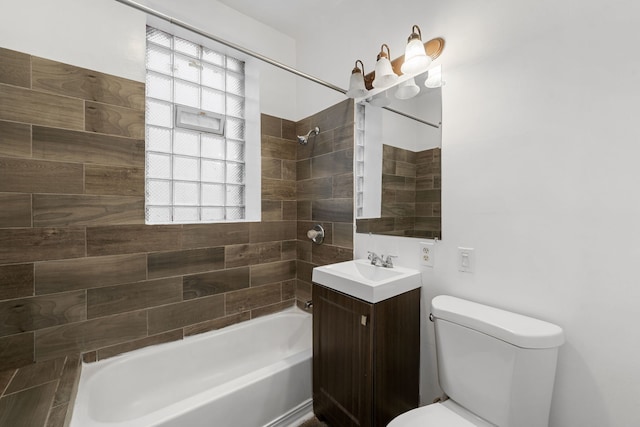 full bathroom with tiled shower / bath, vanity, and toilet