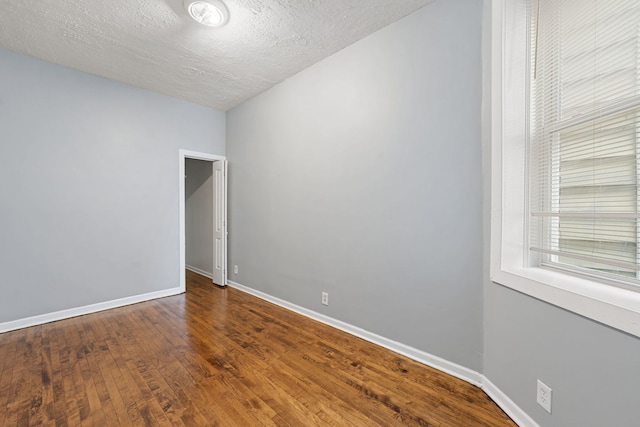 unfurnished room with wood-type flooring and a textured ceiling