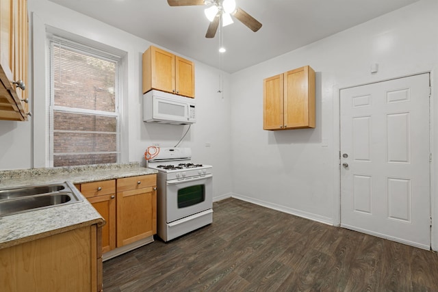 kitchen with sink, white appliances, dark hardwood / wood-style flooring, and ceiling fan