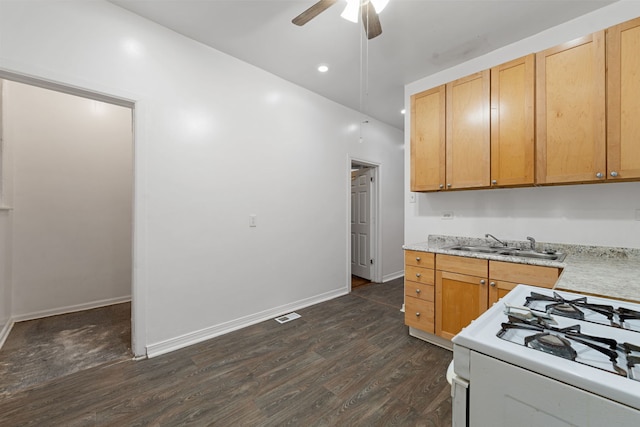 kitchen with light brown cabinetry, sink, white gas range oven, dark hardwood / wood-style floors, and ceiling fan