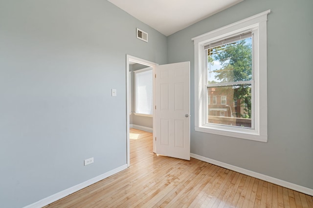 unfurnished room featuring a wealth of natural light and light hardwood / wood-style flooring