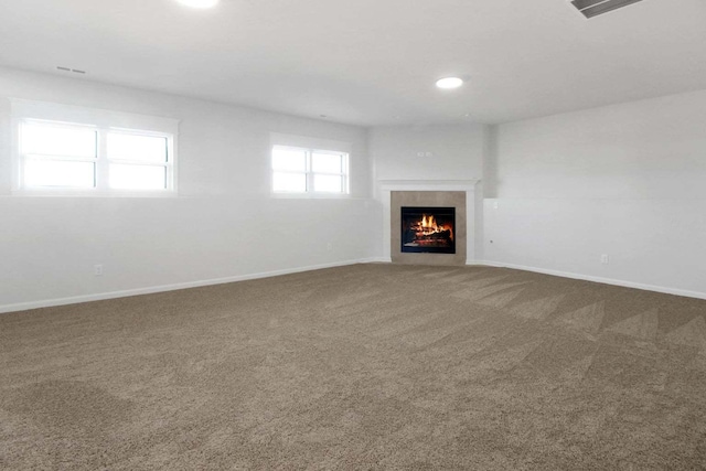 unfurnished living room featuring carpet floors, a fireplace, and baseboards