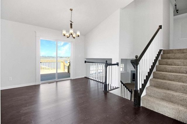 interior space with high vaulted ceiling, baseboards, a chandelier, and wood finished floors