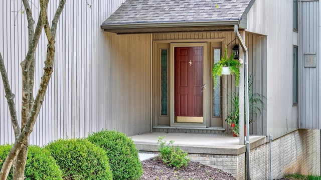 property entrance featuring roof with shingles