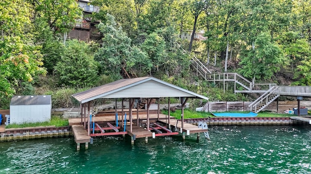 dock area with a water view, boat lift, and stairs