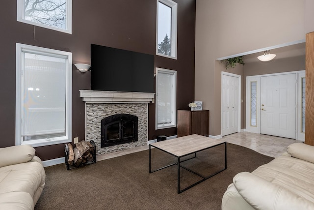 living room featuring carpet, a high ceiling, a fireplace, and baseboards