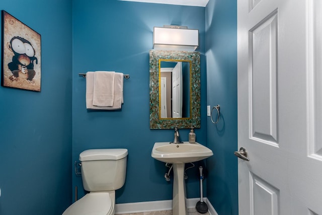 bathroom featuring toilet and baseboards