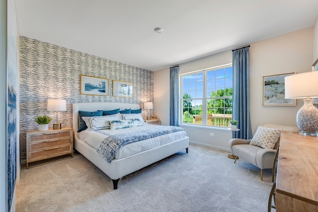 bedroom featuring wallpapered walls, carpet, an accent wall, and baseboards