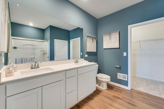 bathroom with an enclosed shower, hardwood / wood-style floors, toilet, and vanity