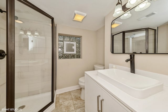 bathroom with vanity, toilet, tile patterned floors, and a shower with shower door