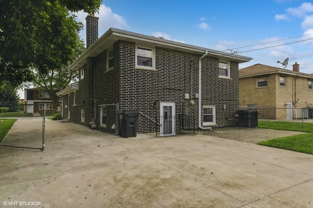 rear view of house with cooling unit and a patio