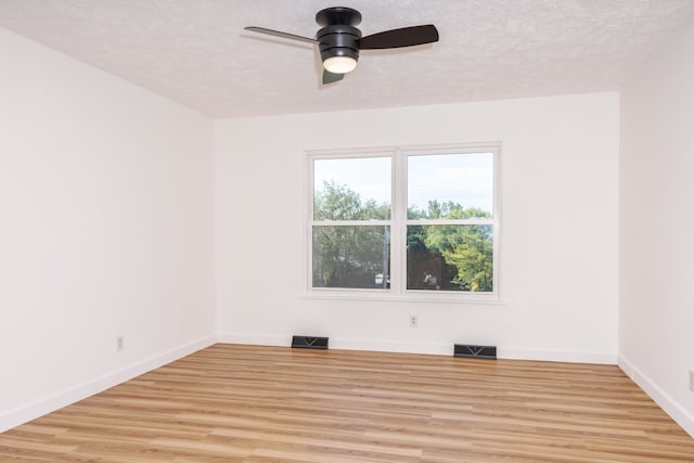 empty room featuring a textured ceiling, ceiling fan, and light hardwood / wood-style floors