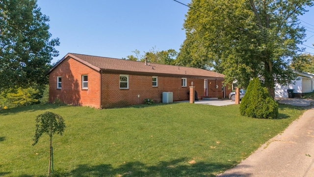 rear view of property featuring a patio and a lawn