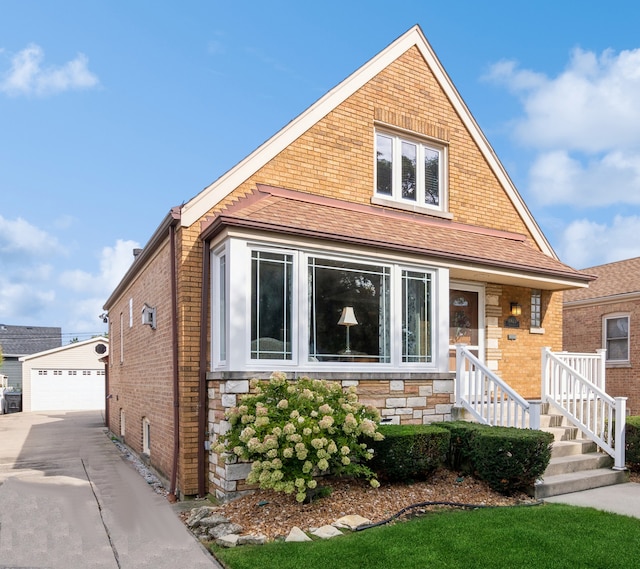 view of front of house with a garage and an outbuilding