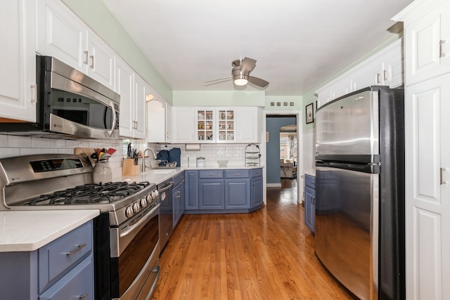 kitchen featuring light hardwood / wood-style flooring, ceiling fan, appliances with stainless steel finishes, and white cabinetry