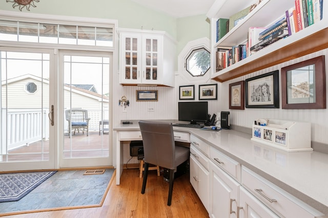 office with built in desk and light hardwood / wood-style floors