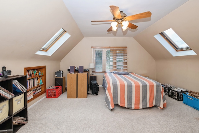 carpeted bedroom featuring ceiling fan and vaulted ceiling with skylight