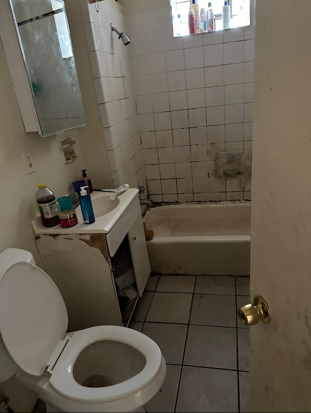 bathroom featuring tiled shower / bath, toilet, and tile patterned flooring