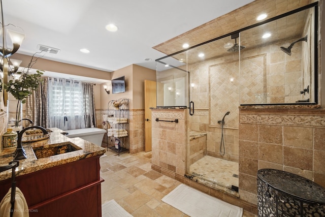 bathroom with tile walls, vanity, and a shower with shower door