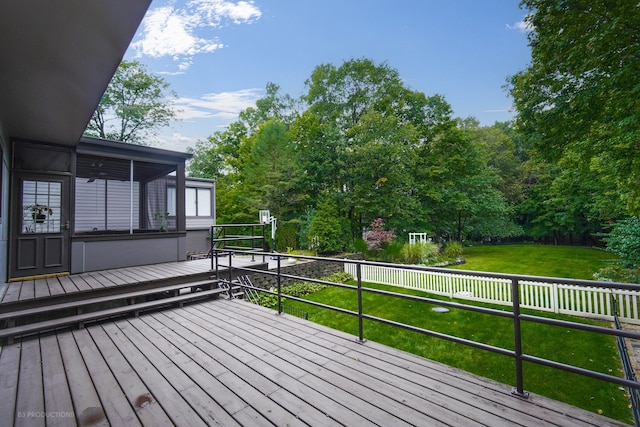 deck featuring a sunroom and a yard