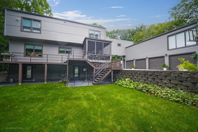 back of property featuring a yard, a deck, a patio, a garage, and a sunroom