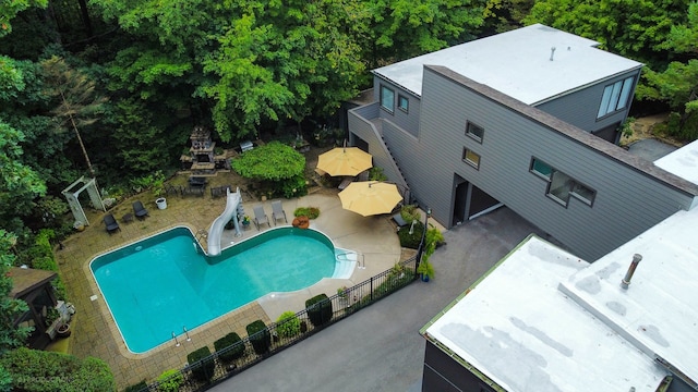 view of pool featuring a water slide and a patio