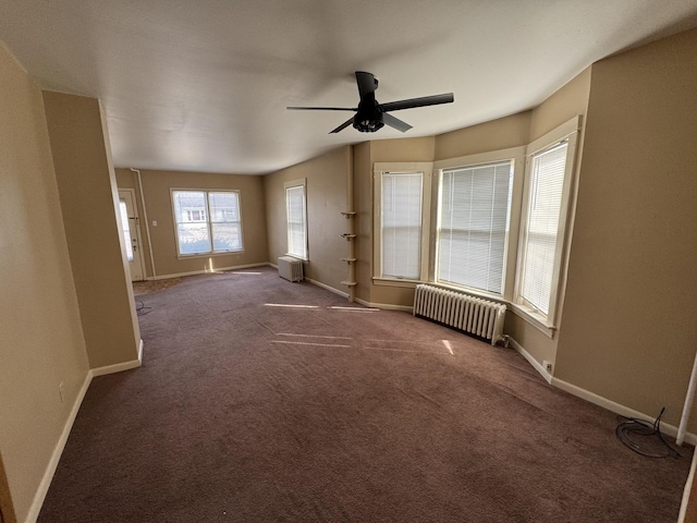 unfurnished living room featuring carpet flooring, baseboards, ceiling fan, and radiator heating unit