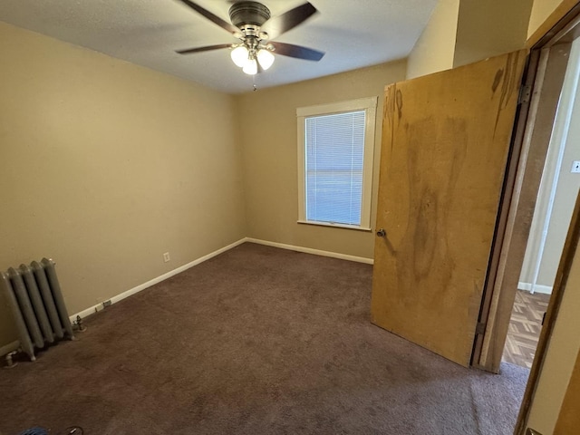 unfurnished room featuring radiator, a ceiling fan, baseboards, and carpet floors