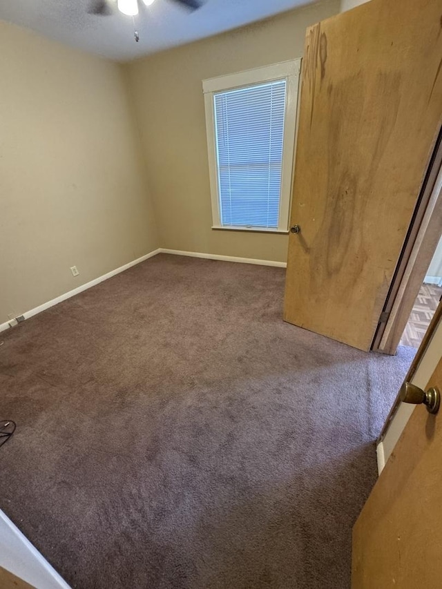 unfurnished room with a ceiling fan, baseboards, and carpet floors