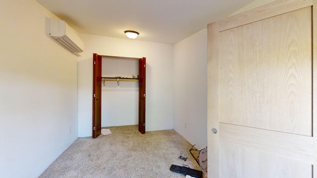 unfurnished bedroom featuring a closet, a wall unit AC, and carpet floors