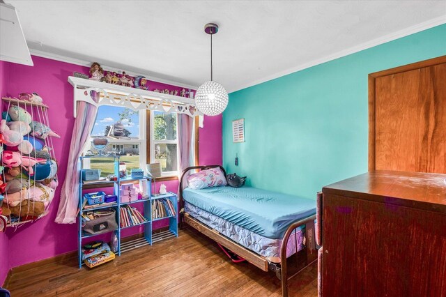 bedroom with wood-type flooring and ornamental molding