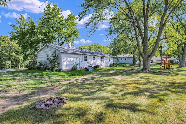 view of yard with a fire pit and a playground