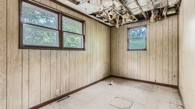 empty room with plenty of natural light and wooden walls