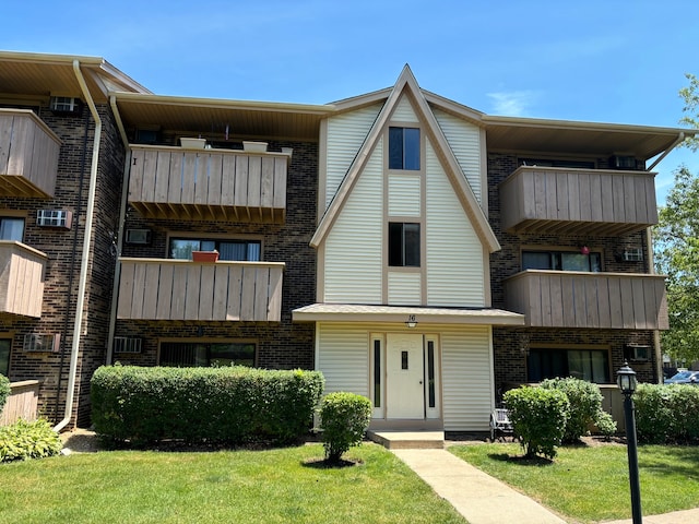 view of front of home featuring a balcony and a front lawn