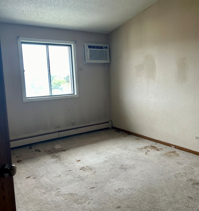 carpeted empty room with a baseboard heating unit, a textured ceiling, and a wall unit AC