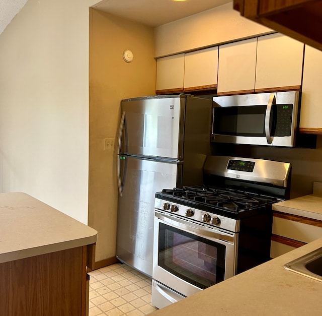 kitchen featuring cream cabinets and appliances with stainless steel finishes