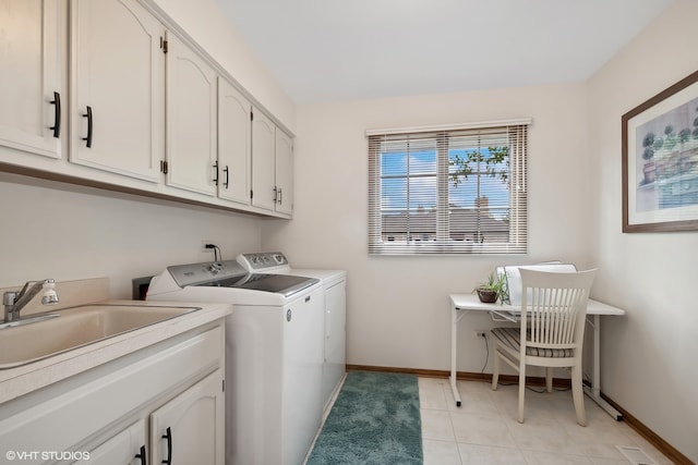 laundry area with cabinets, washer and clothes dryer, sink, and light tile patterned flooring