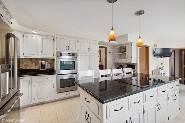 kitchen featuring a kitchen island, decorative light fixtures, appliances with stainless steel finishes, and white cabinets