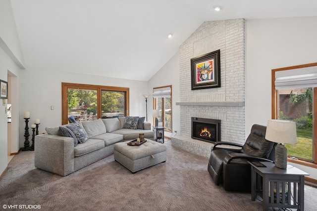 carpeted living room with high vaulted ceiling and a brick fireplace