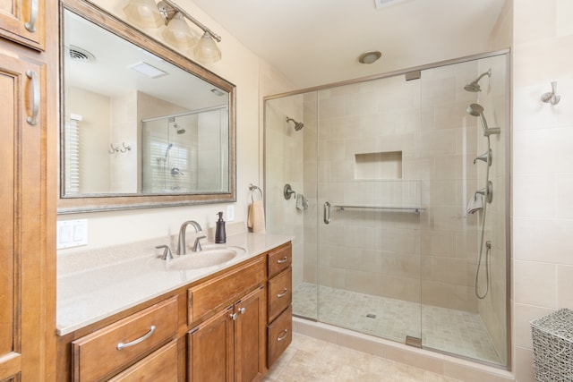 bathroom featuring tile patterned flooring, vanity, and walk in shower