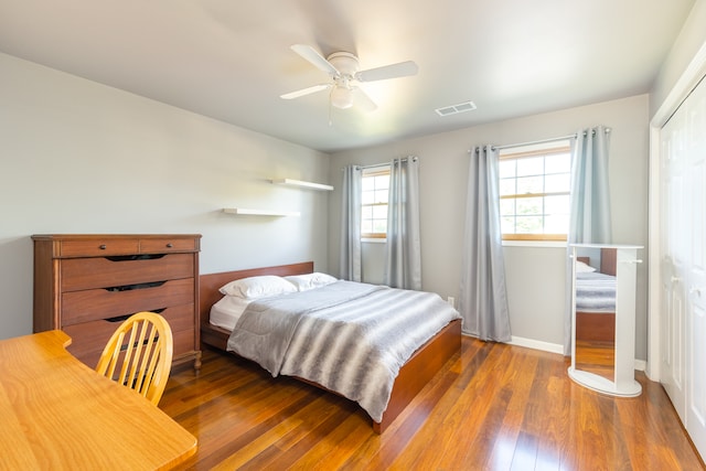 bedroom with ceiling fan, a closet, and wood-type flooring