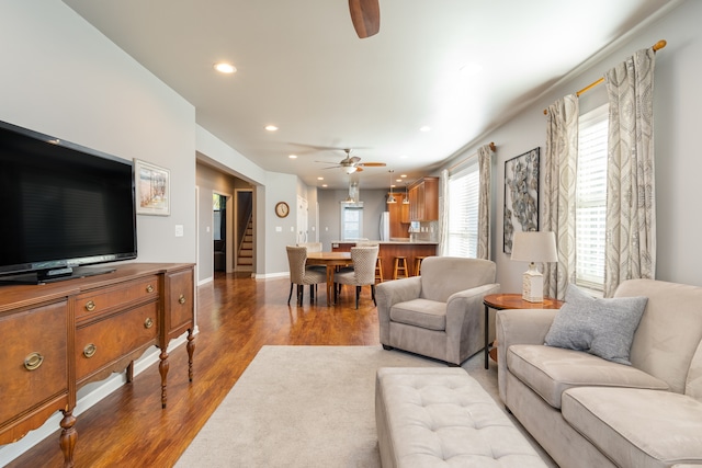 living room featuring light wood-type flooring and ceiling fan