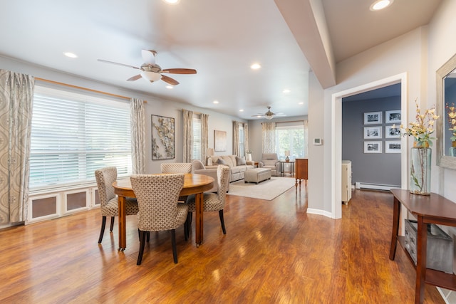 dining space featuring hardwood / wood-style floors, ceiling fan, and baseboard heating