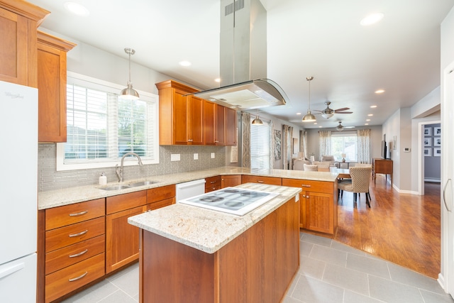 kitchen featuring white appliances, island exhaust hood, sink, ceiling fan, and light wood-type flooring