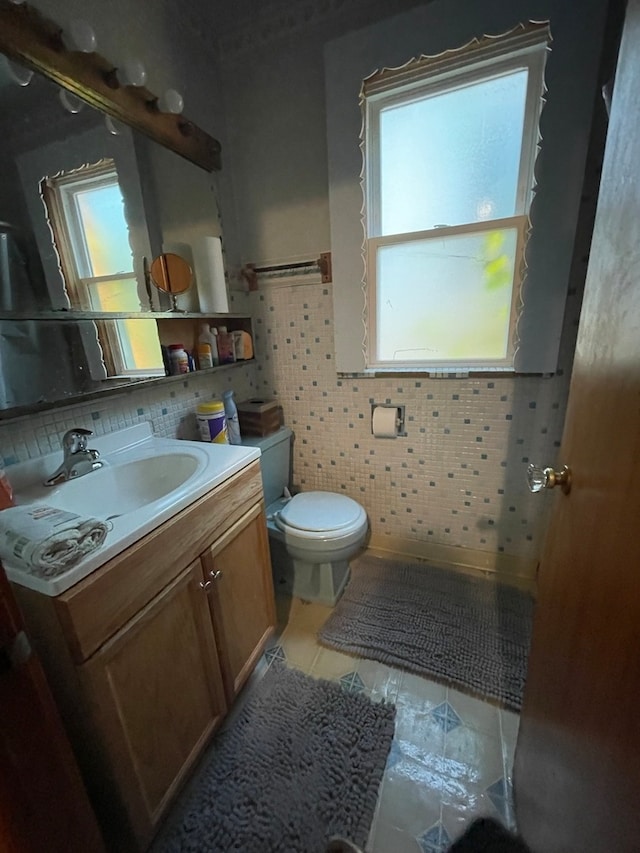 bathroom featuring vanity, toilet, and a healthy amount of sunlight