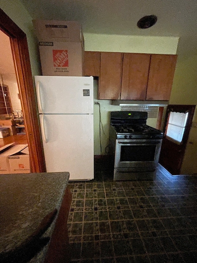 kitchen featuring stainless steel range and white refrigerator