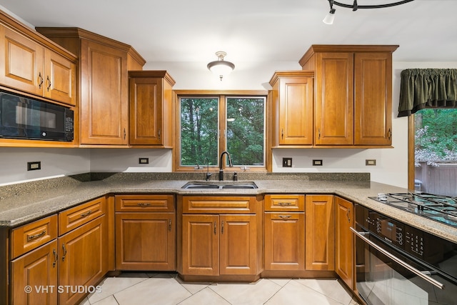 kitchen with black appliances, light tile patterned floors, and sink